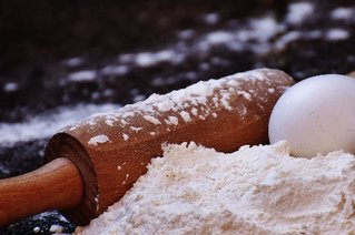 Nudelholz und Ei mit Mehl